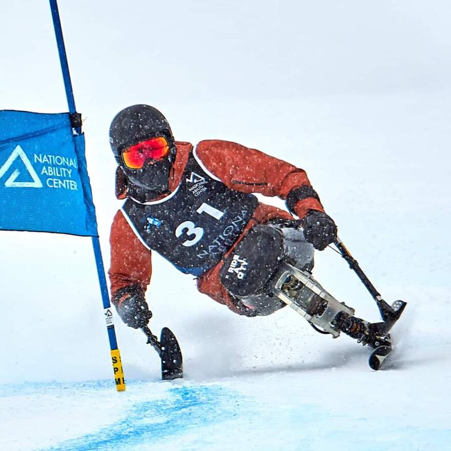 Matthew Brewer in an orange jacket wearing #31 competitive Alpine Skiing event