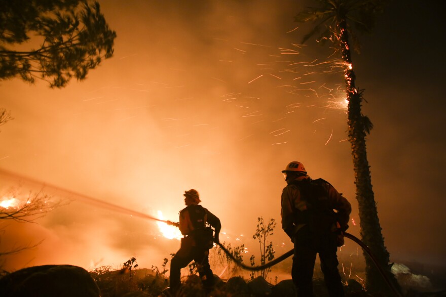 Firefighters battle a wildfire as it burns along a hillside near homes in Santa Paula, California, on December 5, 2017.
Fast-moving, wind-fueled brush fire exploded to about 10,000 acres in Ventura County Monday night, forcing hundreds of people to flee their homes, officials said.  / AFP PHOTO / RINGO CHIU        (Photo credit should read RINGO CHIU/AFP/Getty Images)