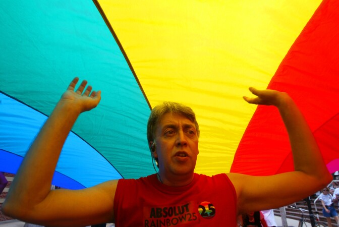 The creator of the first-ever rainbow flag twenty-five years ago, Gilbert Baker, helps stretch the mile and quarter long 'World's longest Rainbow Flag' June 15,2003 from the Gulf of Mexico to the Atlantic coast along Duval street in Key West, Florida. 