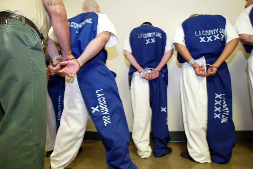 A deputy with the L.A. Sheriff's Department checks the handcuffs of prisoners.