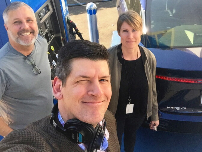 KPCC host John Rabe (foreground) mugs in front of a hydrogen fueling station in South Pasadena with Hydrogen Fuel Cell Partnership spokesman Keith Malone and KPCC motor critic Sue Carpenter.