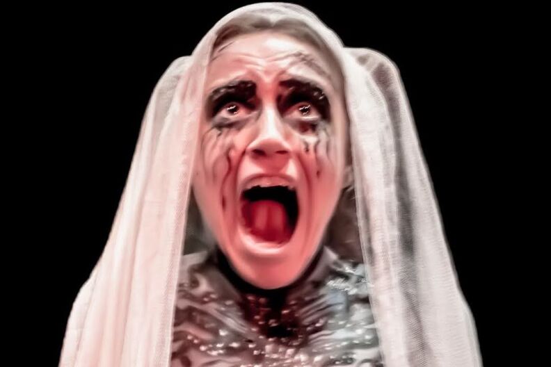 A woman in a white veil screams as her black mascara runs down her face.