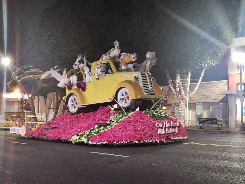 A parade float with many farm animals poking out of a truck.