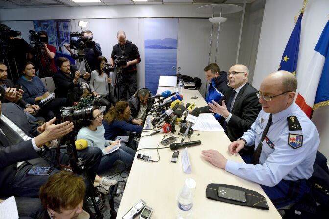 French prosecutor of Marseille Brice Robin (C), flanked by General David Galtier (R), speaks to the press on March 26, 2015 in Marignane airport near the French southern city of Marseille.  The co-pilot "voluntarily" initiated the descent of the Germanwings flight that crashed into the French Alps and refused to open the door to the pilot who was outside the cockpit, the lead investigator said today.  AFP PHOTO / FRANCK PENNANT        (Photo credit should read FRANCK PENNANT/AFP/Getty Images)