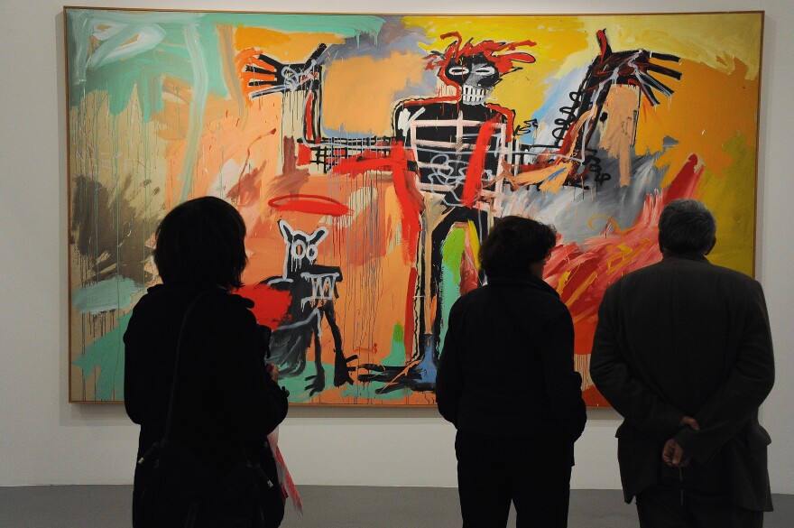 Three people shown in silhouette look at a large, abstract painting of what appears to be a skeleton holding its arms up. A dog is next to the skeleton. The painting uses red, orange, green, brown, black, white, blue, brown and yellow colors. 