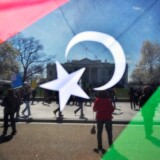 A man waves a Kingdom of Libya flag during an anti-war demonstration in front of the White House in Washington, DC, on March 26, 2011.