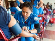 Nursing students check blood pressure during Care Harbor's annual Los Angeles medical clinic at the Los Angeles Memorial Sports Arena on Thursday, Oct. 31.