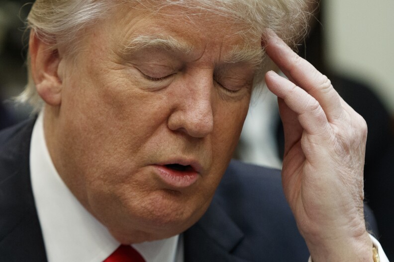 President Donald Trump pauses as he looks at his notes during a meeting with business leaders in the Roosevelt Room of the White House in Washington, Monday, Jan. 30, 2017. (AP Photo/Evan Vucci)