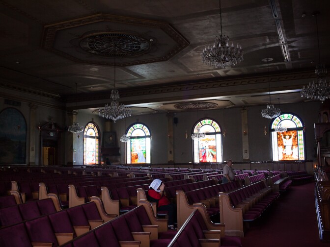 A woman prays at Glendale's St. Mary's Armenian Apostolic Church, where Father Barthev Gulumian once taught.