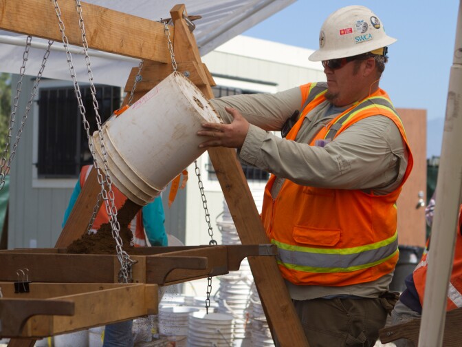 One of dozens of buckets of dirt finds its way into a sifting tray near the San Gabriel Mission.