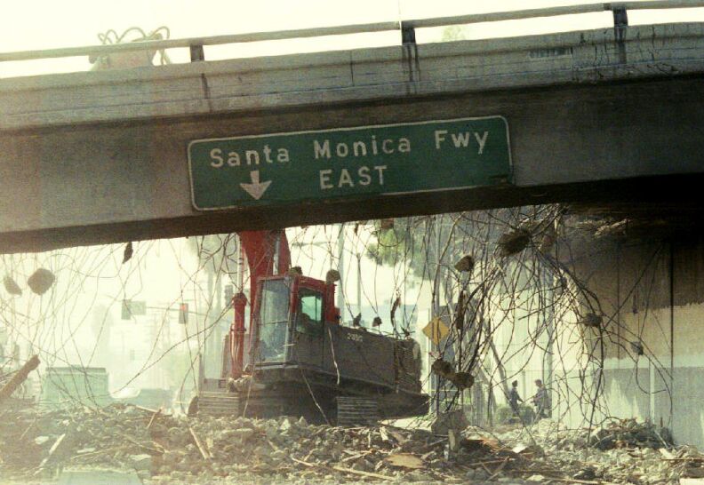 A bulldozer begins to tear down a section of the Santa Monica Freeway Jan. 19, 1994 that collapsed during the Northridge earthquake. Commuters were urged to leave for work two hours earlier due to the 300-foot section of the road that is closed.