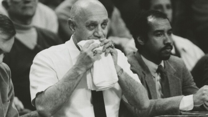Basketball Coach Jerry Tarkanian chewing on a towel during a game out of superstition.