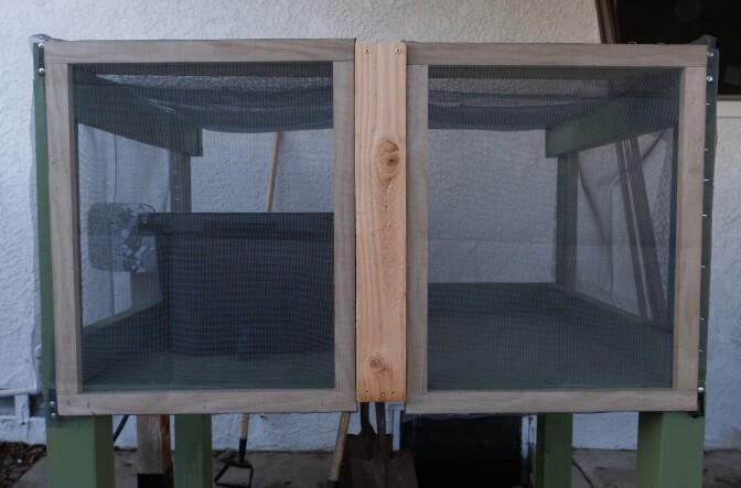 A small structure with a screen holding a black tote.