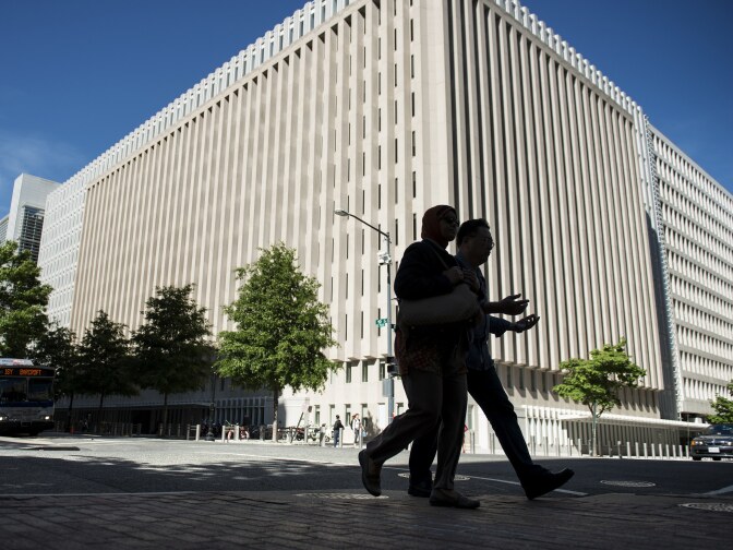 People walk past the World Bank's headquarters in Washington, D.C. A watchdog says that the World Bank is not adequately monitoring how funds intended for Afghanistan reconstruction are being used.