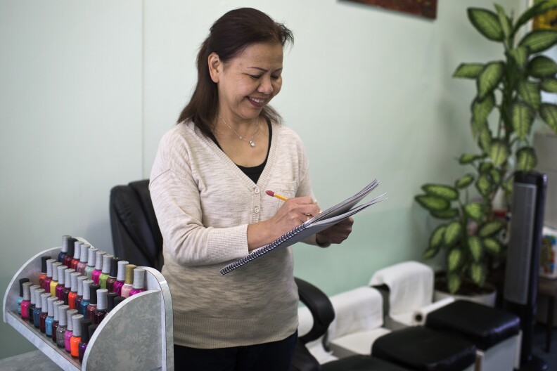 Co-owner Phan Nguyen books an appointment with a regular customer on Wednesday, March 5 at Nancy's Nails. Before coming to the U.S. from Vietnam, Nguyen was a middle school teacher.