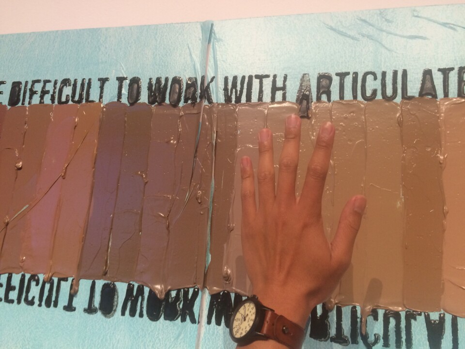 A piece by artist April Bey. KPCC's Leo Duran holds up his own hand to see what adjectives are associated with his skin tone.