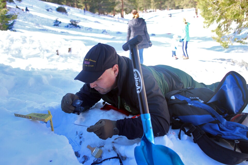 Nathan Judy examines the snow at Manker Flats in the Angeles National Forest. Snow rangers identify areas that may be at risk of avalanche. 