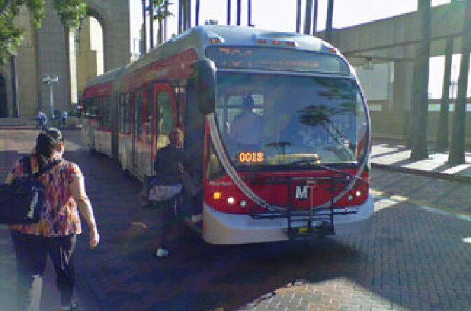 Los Angeles County commuters rush to board the 704 bus at L.A. Union Station. The Metro bus line is one of those affected by cuts and reductions that took effect yesterday.