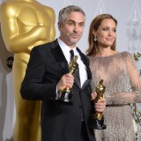 Director Alfonso Cuarón (L), winner of Best Achievement in Directing for 'Gravity', and actress Angelina Jolie pose in the press room during the 86th Academy Awards on March 2nd, 2014 in Hollywood, California.