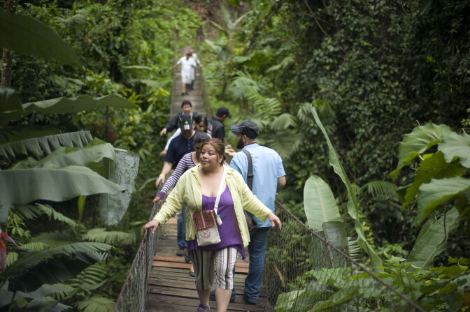 People walk on a hanging bridge in the Patrocinio Natural Reserve in the Quetzaltenango department, 196 km southwest of Guatemala City on June 22, 2012. 