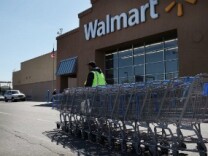 A man pushes carts outside of a Walmart store on March 29, 2011 in Valley Stream, New York.