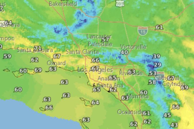 A satellite map includes the Los Angeles, Orange County and Inland Empire areas. The map is colored in shades of yellow, green and blue. Numbers are superimposed on the map to indicate daytime high temperatures. 