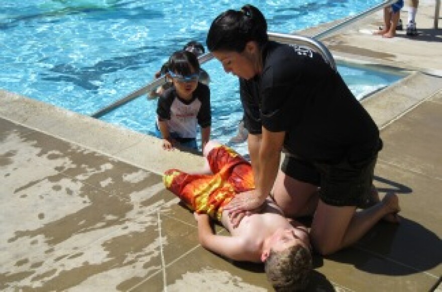 Lynnette Round of the Orange County Fire Authority performs CPR on her son during a mock drowning exercise at a pool in Irvine on Thursday.