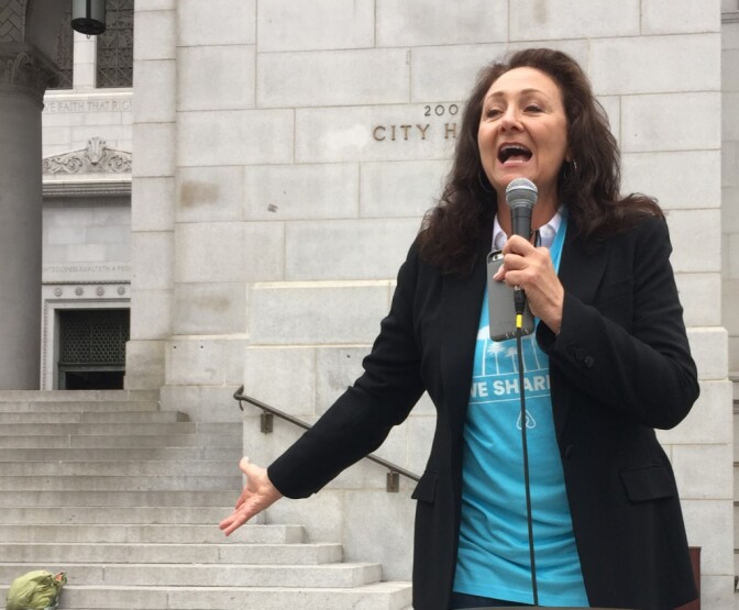 Airbnb host Debbie Pollack helps lead a rally outside City Hall on Wednesday, June 8, 2017.
