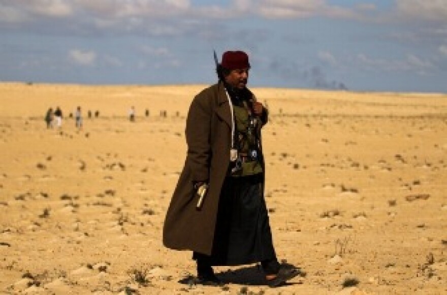 A Libyan rebel wearing an unsual combination of local and military outfits is pictured on March 22, 2011 where rebel forces massed for a second day on several kilometres from the key city of Ajdabiya to try to attack government forces that have encircled the town.