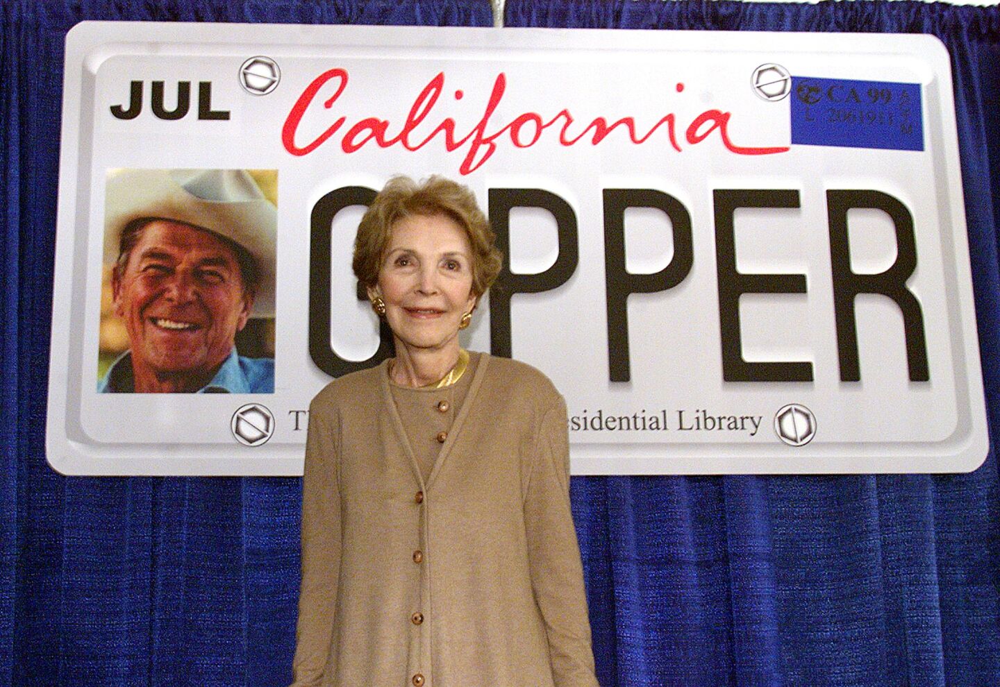 Former First Lady Nancy Reagan poses in front of a proposed design for the Ronald Reagan California state license plate after California Gov. Gray Davis signed legislation authorizing the commemorative plates of the former US President in October 1999.
