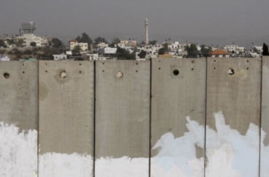 A picture shows Israel's controversial separation barrier and in the background a minaret of a mosque in the Palestinian village of Masha in the West Bank city, on September 26, 2010.