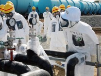 A Japanese utility said Monday its crippled Fukushima nuclear plant is likely leaking contaminated water into sea, acknowledging for the first time a problem long suspected by experts. (File photo: Nuclear Regulation Authority (NRA) Secretary General Shunichi Tanaka (R, w/white helmet) inspects the radioactive water-leaked plumbing with Tokyo Electric Power Co. (TEPCO) officials at the Fukushima Dai-Ichi nuclear power plant in Okuma in Fukushima prefecture, on April 13, 2013.)