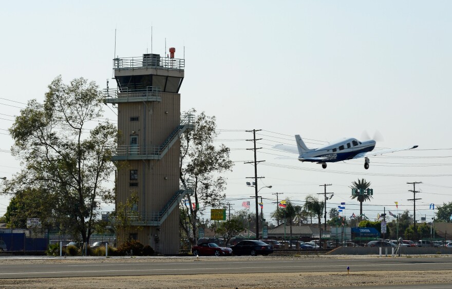 A plane passes the Whiteman Airport control tower as it takes off on March 22, 2013 in Los Angeles, California.