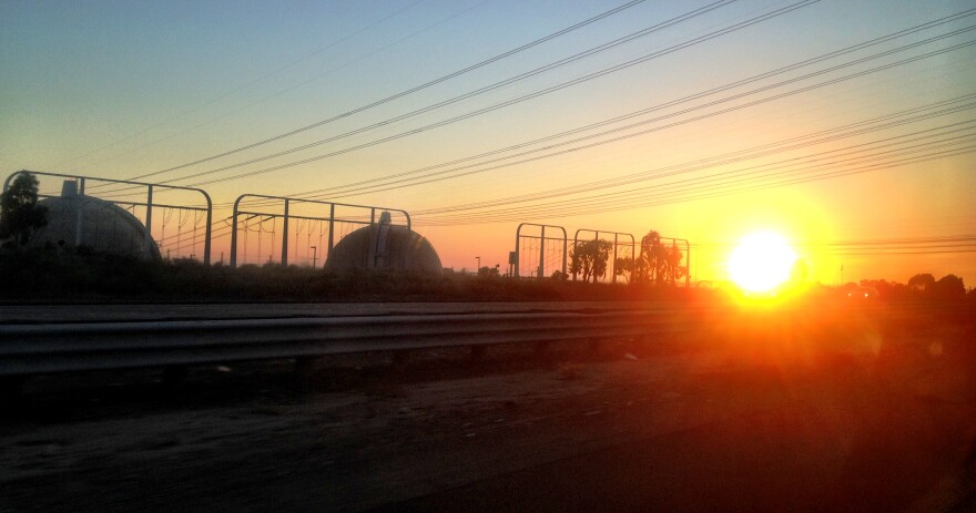 A public workshop Tuesday about safety and the storage of radioactive nuclear waste at the closed San Onofre nuclear plant is not as public as some activists would like it to be. (Photo: The sun sets behind the San Onofre Nuclear Generating Station in northern San Diego County).
