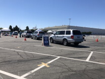 An image of cars lined up at a parking lot to get passengers in line for a COVID test.