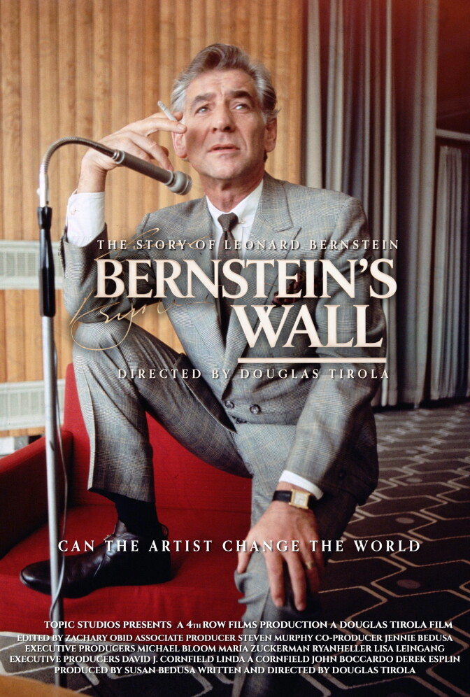 A light-skinned man in a gray suit sits with a cigarette in one hand. Text over top says "Bernstein's Wall"