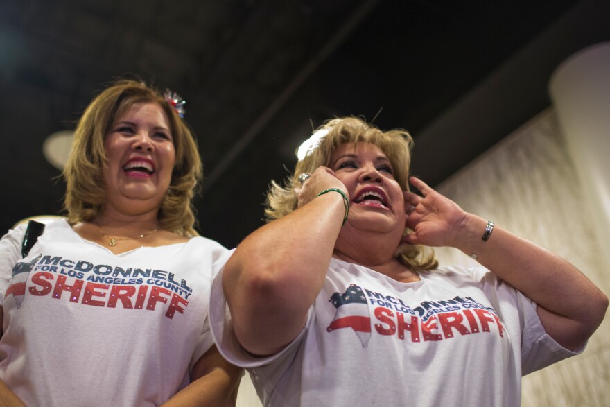 Monica Harman, left, of Speak Out Against Bullying and Michele Arce of the East Los Angeles Chamber wear shirts supporting Los Angeles County Sheriff candidate Jim McDonnell during his election gathering at the JW Marriott in downtown Los Angeles on Tuesday night, June 3. Harman and Arce have known McDonnell for almost two decades.