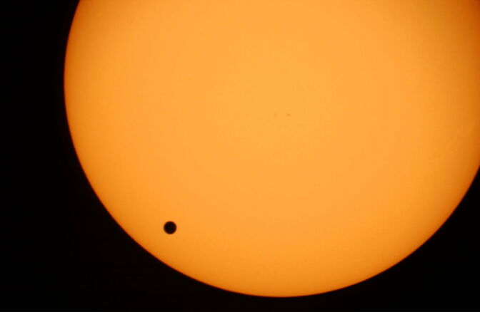A file photo of the planet Venus, black spot, crossing the sun. It was photographed through a telescope at Planetarium Urania in Hove, Belgium, in June 2004. On June 5, Venus will pass across the face of the sun, producing a silhouette that no one alive today will likely see again. Transits of Venus are very rare, coming in pairs separated by more than a hundred years. This June's transit, the bookend of a 2004-2012 pair, won't be repeated until the year 2117. Fortunately, the event is widely visible.