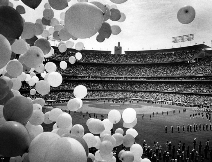 White balloons are in the foreground of a packed Dodger Stadium.