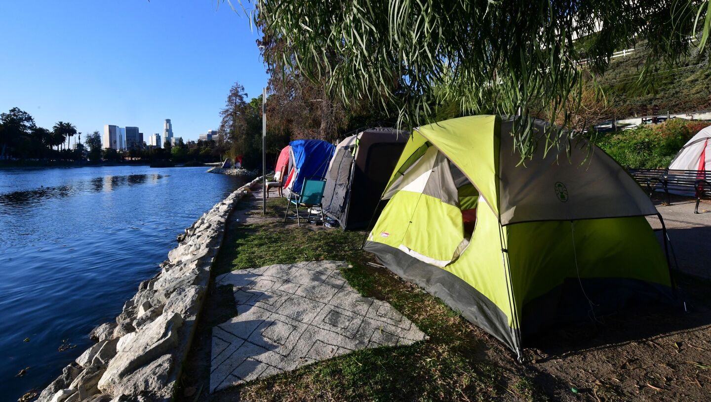 Three tents lined up along the shore of Echo Park Lake in Los Angeles before the homeless encampment was cleared out.