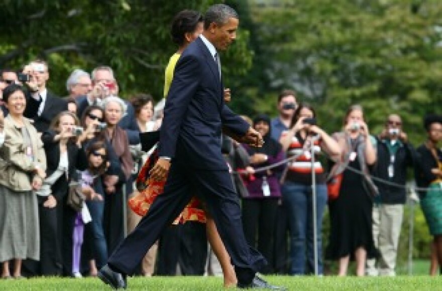 President Barack Obama walks with first lady Michelle Obama, toward Marine One while departing the White House.