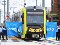 Los Angeles County Metropolitan Transportation Authority (Metro) employees hold up a banner for the first train in 53 years to break through, on arrival at Santa Monica station in Santa Monica, California on May 20, 2016.
The USD 1.5 billion extension connects the Expo Line from its current end location near Venice and Robertson boulevards to downtown Santa Monica.  / AFP / FREDERIC J. BROWN        (Photo credit should read FREDERIC J. BROWN/AFP/Getty Images)