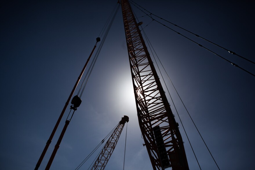 Cranes tower over the initial construction areas of a $1 billion bridge to replace the aging Gerald Desmond Bridge linking the ports of Los Angeles and Long Beach.