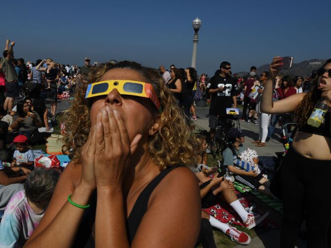 Cherri Haghighit views the start of the total solar eclipse at the Griffith Observatory in Los Angeles, California, on August 21, 2017.
Emotional sky-gazers on the US West Coast cheered and applauded Monday as the Sun briefly vanished behind the Moon -- a rare total solar eclipse that will stretch across North America for the first time in nearly a century.



 / AFP PHOTO / Mark RALSTON        (Photo credit should read MARK RALSTON/AFP/Getty Images)