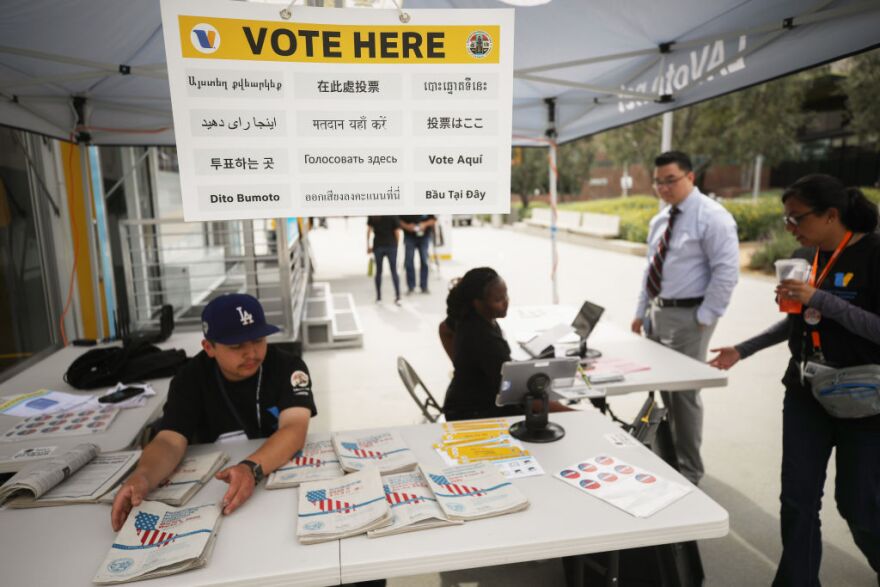 LOS ANGELES, CALIFORNIA - FEBRUARY 27: A voter (2nd R) checks in before entering a voting booth during early voting for the California presidential primary election at a new L.A. County ‘Mobile Vote Center’ in Grand Park on February 27, 2020 in Los Angeles, California. Los Angeles County and several other counties in California have transitioned from polling places to ‘vote centers’ which allow residents the freedom to vote in any vote center in the county. California is one of 14 states participating in the Super Tuesday vote on March 3.  (Photo by Mario Tama/Getty Images)