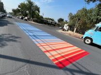A street painted with bright red and baby blue colors symbolizing a heat scale.