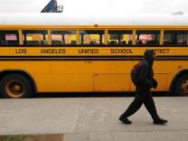  A student walks past a LAUSD school bus.