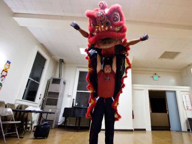 Man Tran and Mark Elefane do an "Eagle kick." Both performers have a martial arts background, helping them perform the traditional lion dancing with the troupe's own acrobatic style.