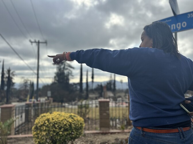 A woman points to the left out to her street.
