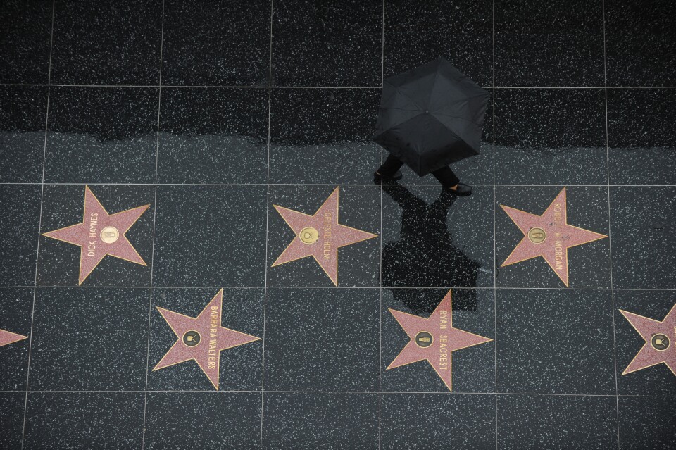 A tourist walks in the rain on the stars of the Hollywood Walk of Fame in Hollywood, California, on December 22, 2010. Downtown Los Angeles received one-third of its annual average rainfall in less than a week. As of midmorning yesterday, the rain gauge at the University of Southern California campus recorded 5.77 inches(14.6cm). AFP PHOTO / GABRIEL BOUYS (Photo credit should read GABRIEL BOUYS/AFP/Getty Images)